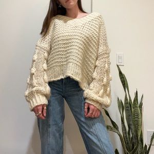 Cream chunky knot sweater with puff ball oversized sleeves